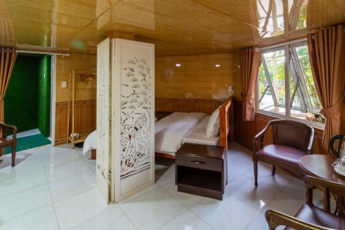 a bedroom with a bed and a table and chairs at Robins Guesthouse in Da Lat