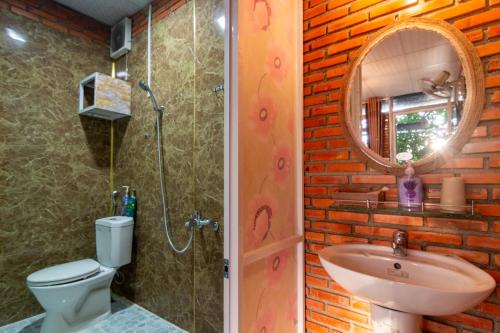 a bathroom with a sink and a toilet and a mirror at Robins Guesthouse in Da Lat