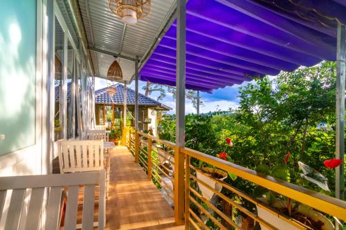 a porch of a house with a purple awning at Robins Guesthouse in Da Lat