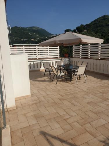 un patio avec une table, des chaises et un parasol dans l'établissement Fradalisa Delizioso monolocale a Vico Equense, à Vico Equense