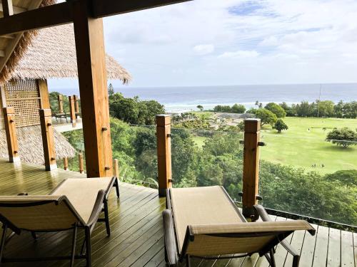 a deck with chairs and a view of the ocean at The Links in Rarotonga