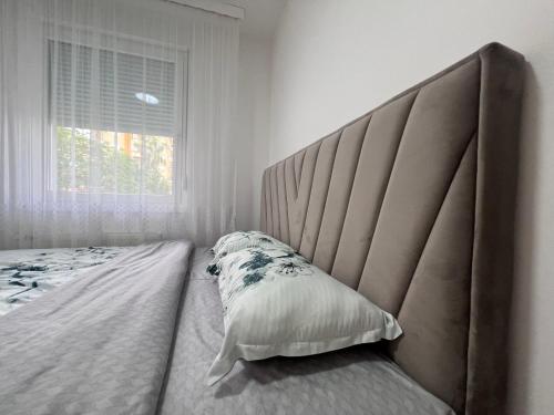 un letto con una grande testiera in una camera da letto di Romanijska a Banja Luka