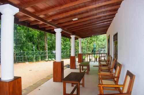 PolatagamaPolatagama Jungle Eco Resort的有一排椅子和桌子的门廊