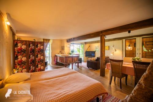 a bedroom with a bed and a living room at Gîte in Castex