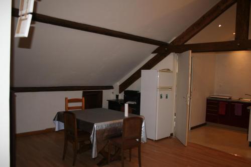 une cuisine avec une table et des chaises et un réfrigérateur blanc dans l'établissement bibi, à Cransac