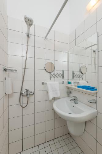 a white bathroom with a sink and a shower at Soleil Village & Villas in Jal