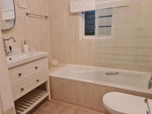 a bathroom with a tub and a toilet and a sink at Casa dos Arcos in Olhos de Água