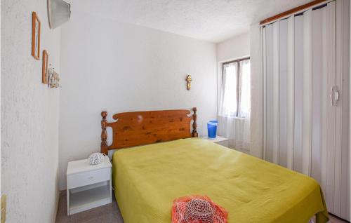 Un dormitorio con una cama amarilla y una ventana. en 1 Bedroom Cozy Home In Costa Paradiso, en Costa Paradiso