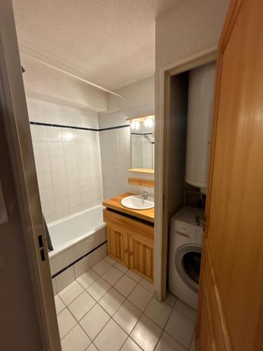 La salle de bains est pourvue d'un lavabo et d'un lave-linge. dans l'établissement Appartement bonne situation ,exposition, à Saint-Chaffrey