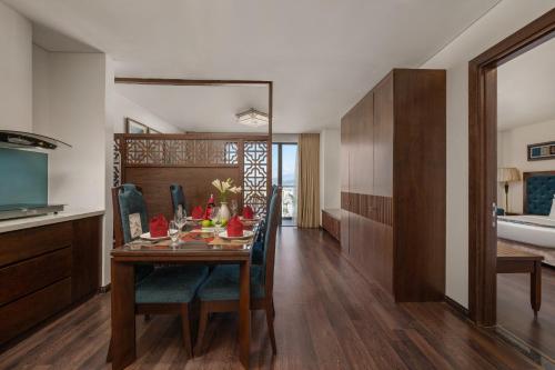 a dining room with a table and chairs and a bathroom at Balcona Hotel Da Nang in Da Nang