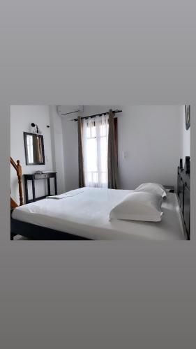 a large white bed in a room with a window at Kasos Almyra Beach Suites in Frý