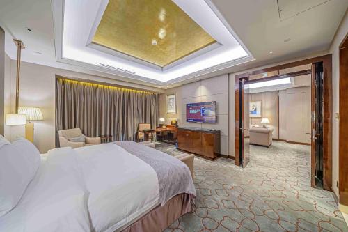 a hotel room with a large bed and a television at Zhaolin Grand Hotel in Beijing