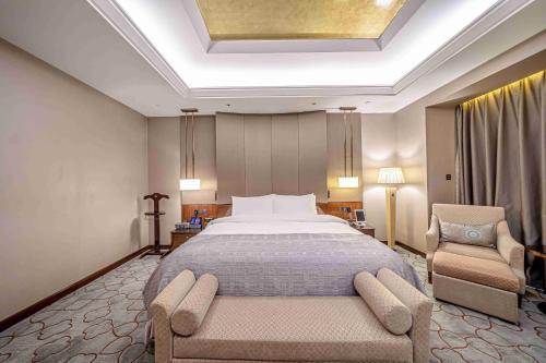 a bedroom with a large bed and a chair at Zhaolin Grand Hotel in Beijing