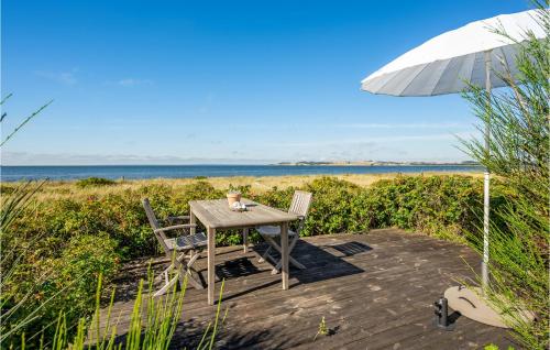a table with two chairs and an umbrella on the beach at Awesome Home In Knebel With Kitchen in Knebel