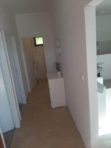 a hallway of a kitchen with a white wall at Apartment By The Sea Marko in Banj