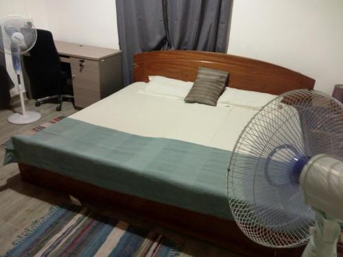 a bedroom with a bed with a fan on it at Atakwame Island in Atimpoko