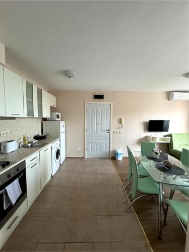 a kitchen and dining room with a table and chairs at Sea view Prestige Fort beach Apartment in Sveti Vlas
