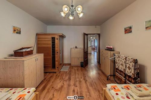 a bedroom with wooden floors and a ceiling fan at Vackor Vendégház Gerjen in Gerjen