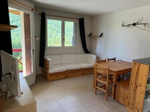 un salon avec un canapé et une table dans l'établissement Appartement bonne situation ,exposition, à Saint-Chaffrey