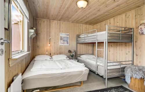 two bunk beds in a room with wooden walls at 1 Bedroom Lovely Home In Løgstør in Løgstør