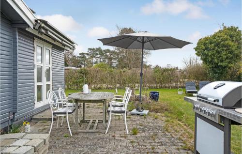 a patio with an umbrella and a table and chairs at Amazing Home In Rødvig Stevns With Wifi in Rødvig