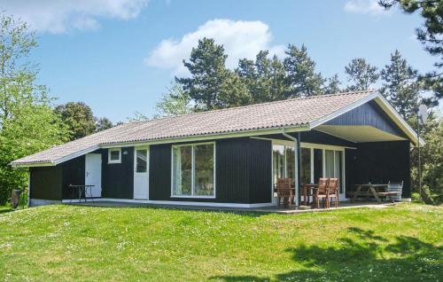 a small black house with a patio and grass at Holiday Home Ristinge Sommerland Humble I in Humble