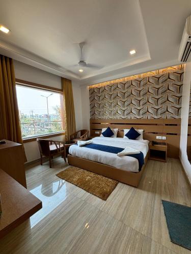 a bedroom with a large bed and a large window at Hotel Royal Casa in Lucknow