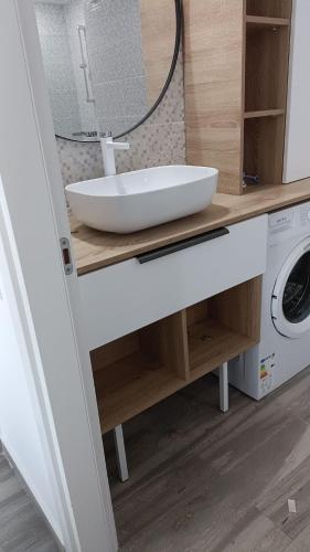 a bathroom with a sink and a washing machine at Aphrodite Olimp - Luxury apartment with sea view & pool in Olimp