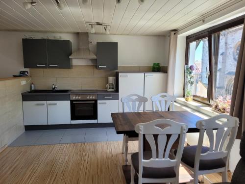 a kitchen with a wooden table and white cabinets at Marktstube in Marsberg