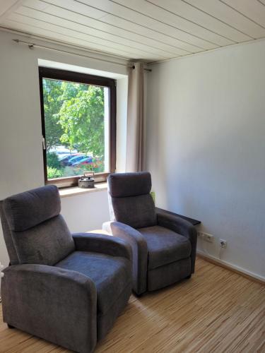two chairs and a chair in a room with a window at Marktstube in Marsberg