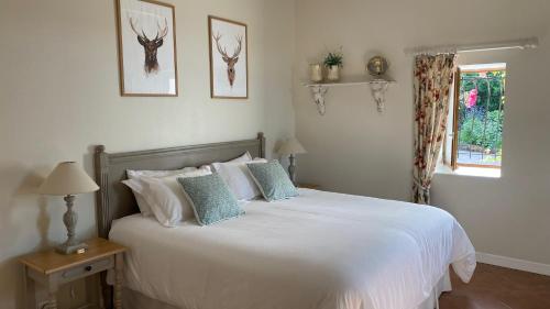 a bedroom with a white bed with two deer heads on the wall at Chambres d'Hôtes Secret Pyrenées in Lasseube
