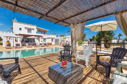 een patio met stoelen en een tafel naast een zwembad bij Tenuta La Cornola by BarbarHouse in Taurisano