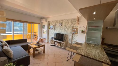 a living room with a couch and a tv at Três palmeiras with pool in Portimão