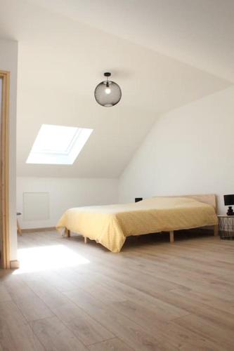 a bed in a white room with a window at Maison 4 chambres 90 m in Aulnoye-Aymeries