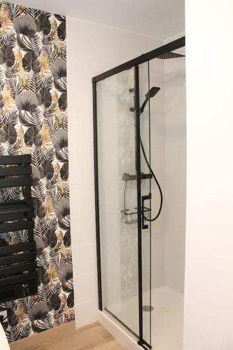 a glass shower in a room with a wall at Maison 4 chambres 90 m in Aulnoye-Aymeries