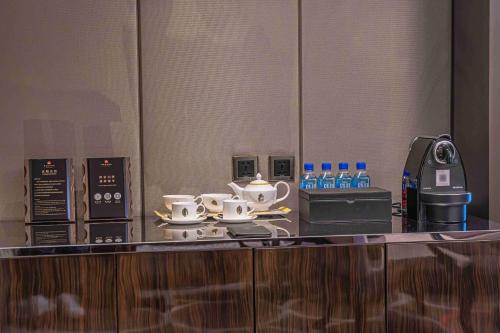 a counter with cups and saucers on top at Zhaolin Grand Hotel in Beijing