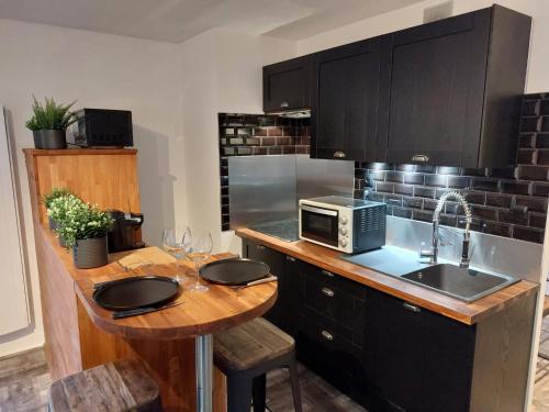 ジェクスにあるAppartement Cosy Parking Gratuitのキッチン(シンク、電子レンジ、テーブル付)