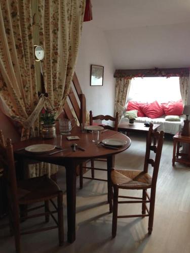 une salle à manger avec une table, des chaises et un canapé dans l'établissement Terrasse sur mer, 2 personnes, au Crotoy