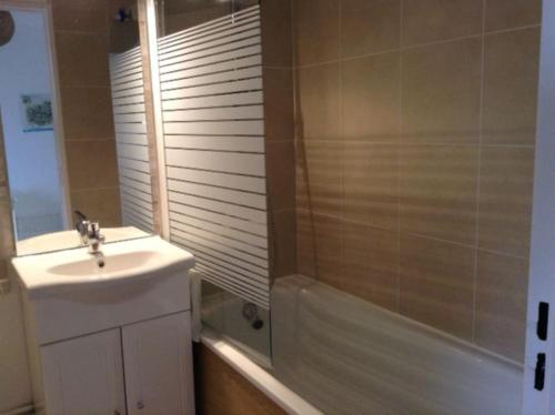 une salle de bain avec un lavabo et une baignoire et un lavabo dans l'établissement Terrasse sur mer, 2 personnes, au Crotoy