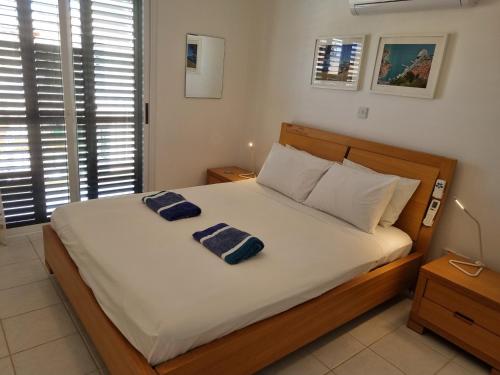 a bedroom with a bed with two towels on it at Cyprus Townhouse Pool Patio Aircon Free Parking in Polis Chrysochous