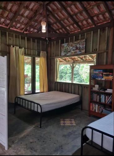 a bedroom with a bed in a room with windows at Vila Dravida Petar in Iporanga