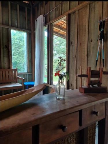 a room with a wooden table with a vase on it at Vila Dravida Petar in Iporanga