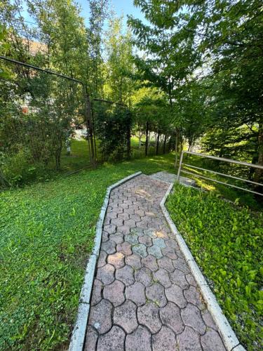 a stone path in a park with trees and grass at Villa RELAX Miševići in Sarajevo