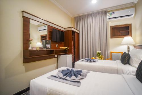 a hotel room with two beds and a kitchen at Emaar Al Khalil in Makkah