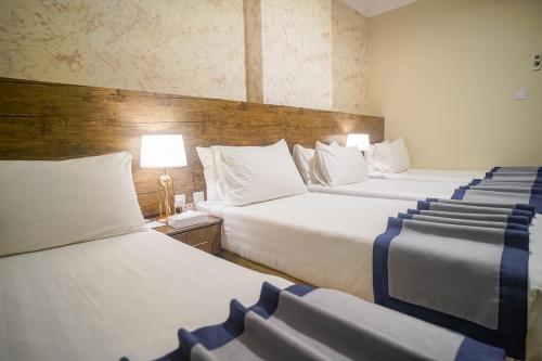 a hotel room with two beds and a lamp at Emaar Al Khalil in Makkah