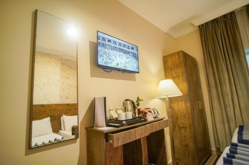 a room with a mirror and a tv on the wall at Emaar Al Khalil in Makkah