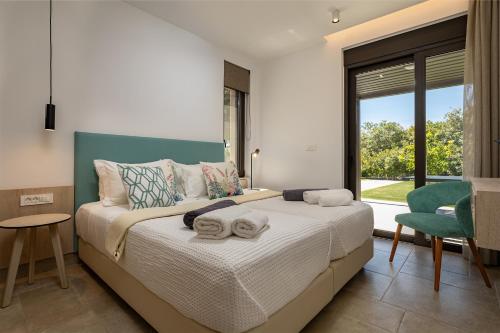 a bedroom with a bed with towels on it at Iniada Villas in Chania Town