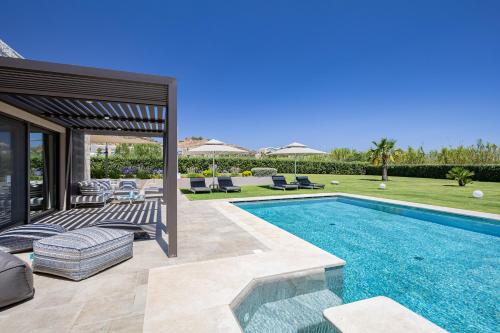 a villa with a swimming pool and a patio at Iniada Villas in Chania Town