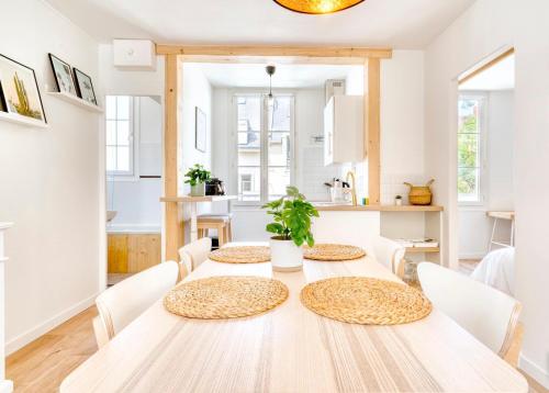 une salle à manger blanche avec une table et des chaises dans l'établissement Le petit coin de la rue Basse, à Caen