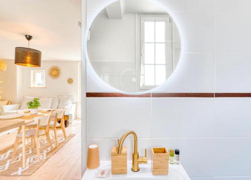 a kitchen and dining room with a sink and a mirror at Le petit coin de la rue Basse in Caen